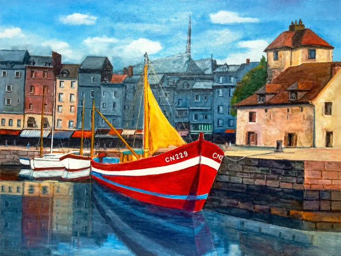 Un bateau à coque rouge et voile jaune sur l’eau